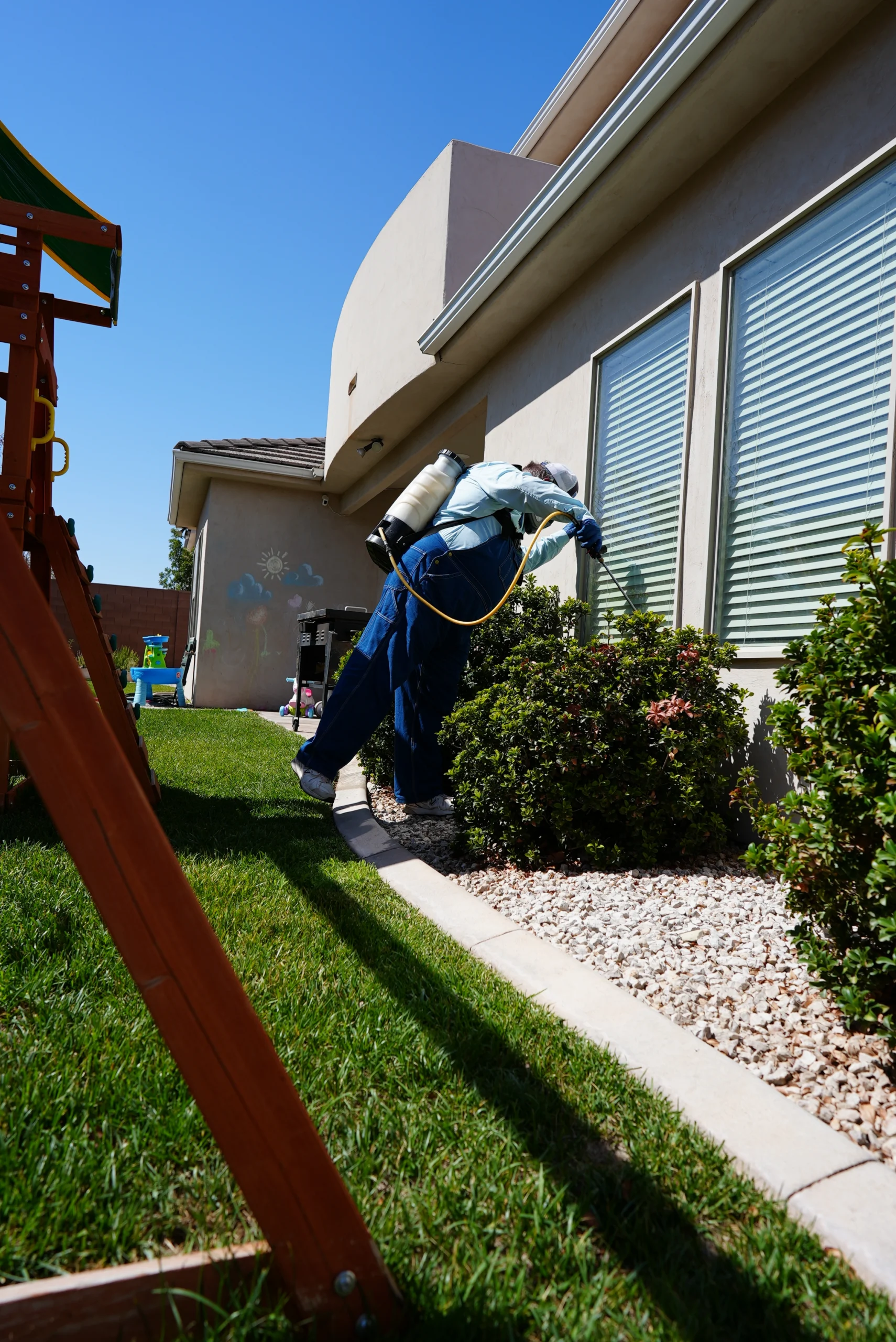 Best Overalls technician treating home and shrubs and bushes for insects and spiders