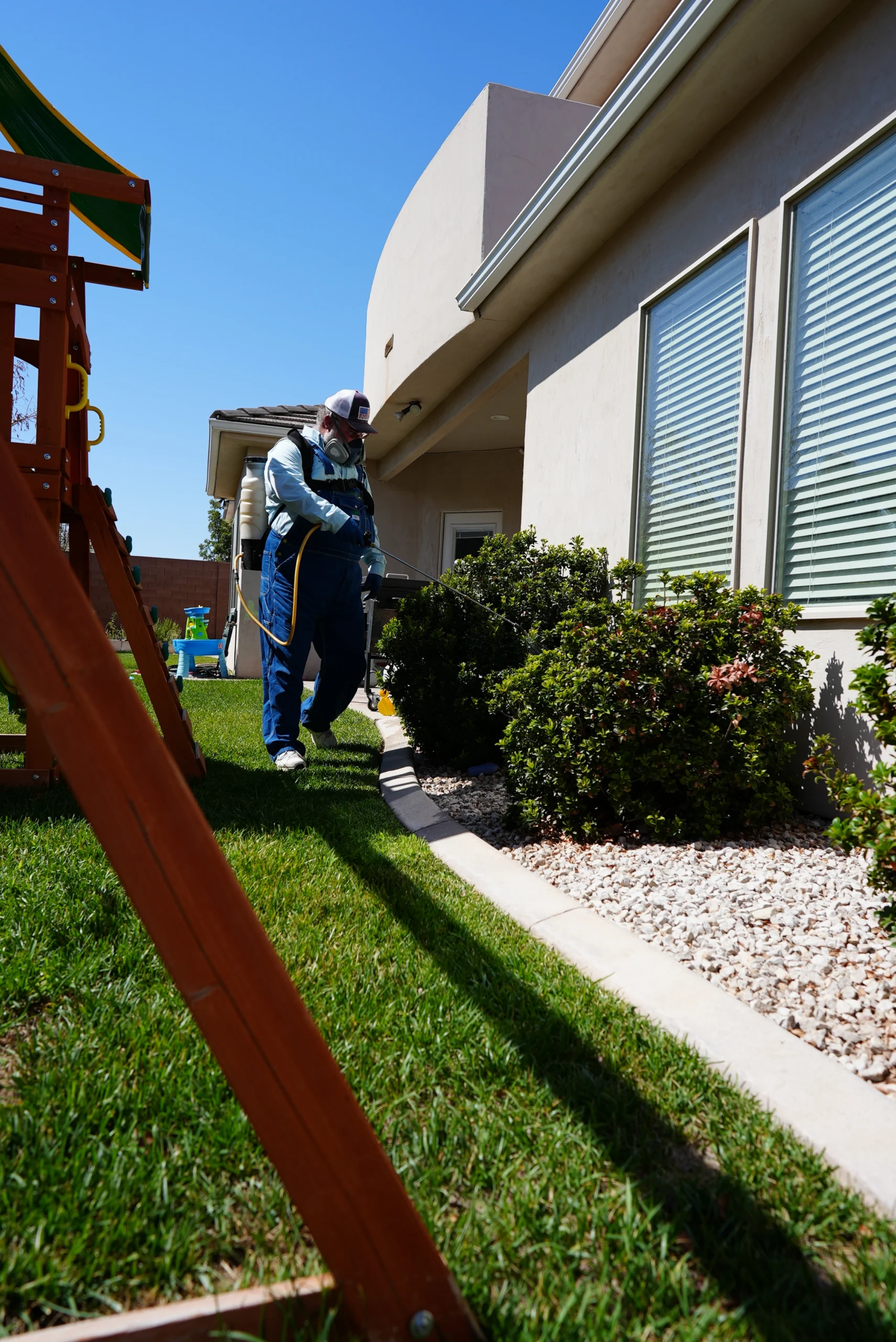 Best Overalls technician treating home and shrubs and bushes for insects and spiders